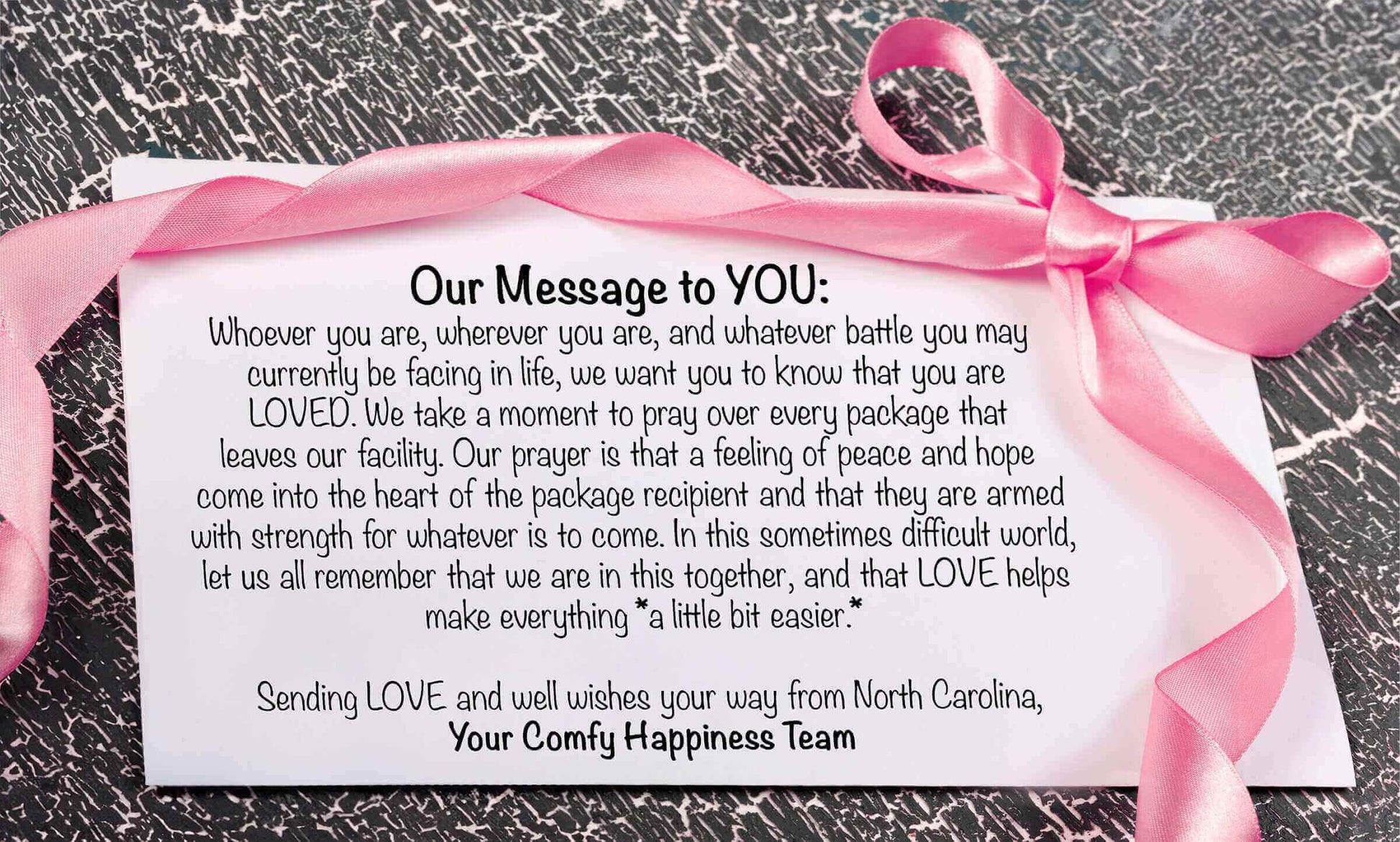Message card with pink ribbon, expressing love and support from Your Comfy Happiness Team.
